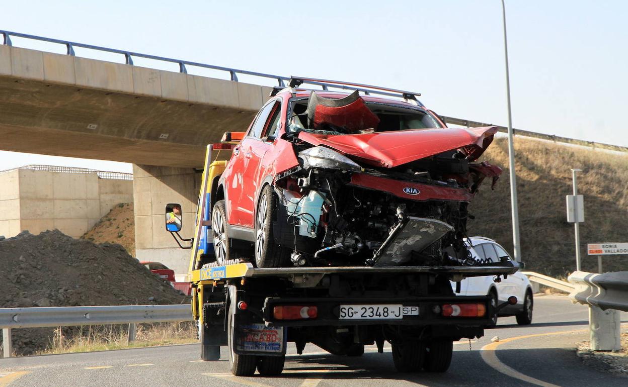 Una grúa transporta los restos de un coche accidentado en la CL-601, en Segovia. 