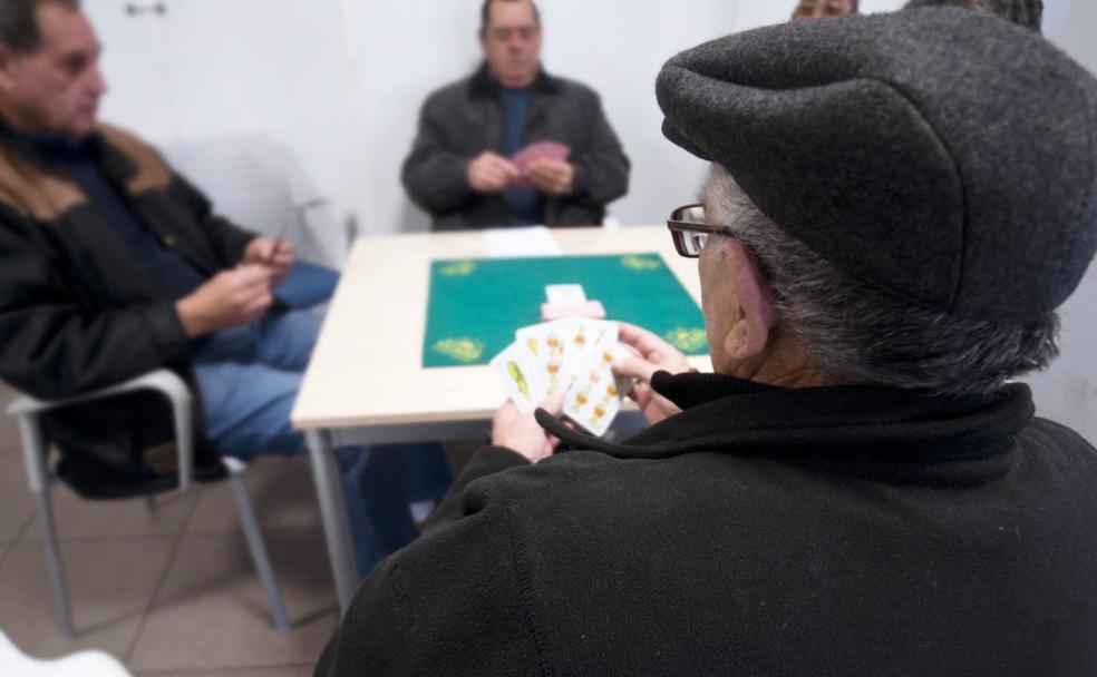 Un grupo de mayores juegan la partida en un hogar del jubilado.