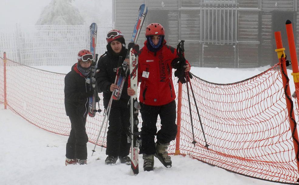 Tres escquiadores de disponen a practicar su deporte favorito en las pistas de Navacerrada, este martes. 