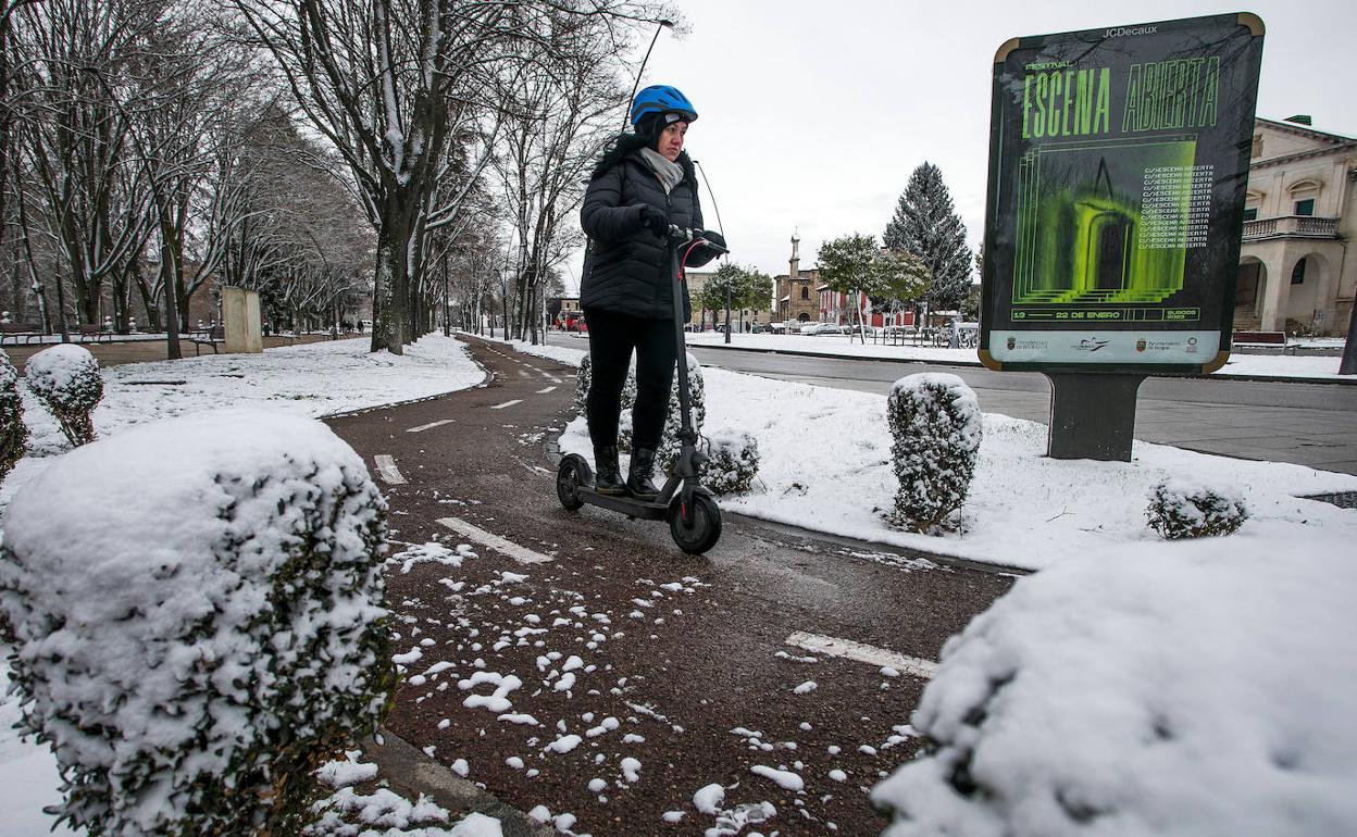 Una mujer conduce un patinete eléctrico por una calle cubierta de nieve, la semana pasada en Burgos. 