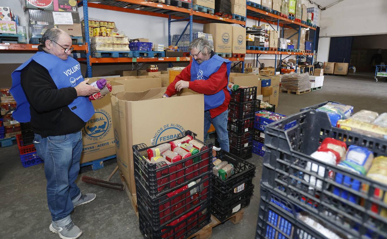 Dos voluntarios del Banco de Alimentos de Palencia  clasifican los alimentos donados en la sede.