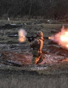 Imagen secundaria 2 - Arriba, un soldado británico instruye a soldados de Kiev en el uso de Javelin. Abajo, un tanque ruso destrozados y un militar ucraniano disparando un lanzagranadas.