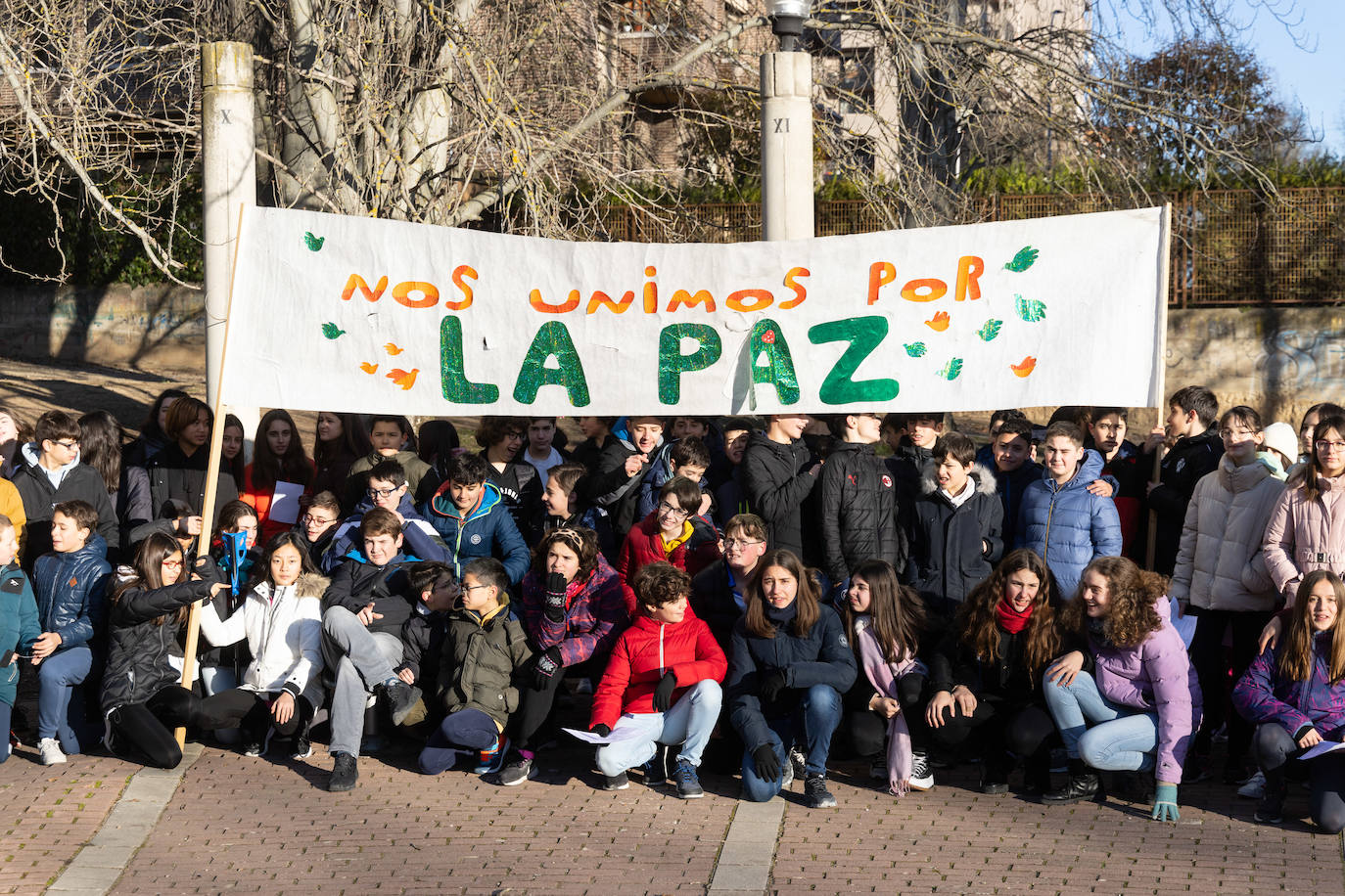 Varios niños y niñas del IES Parquesol sostienen pancartas para conmemorar el Día Mundial de la Paz.