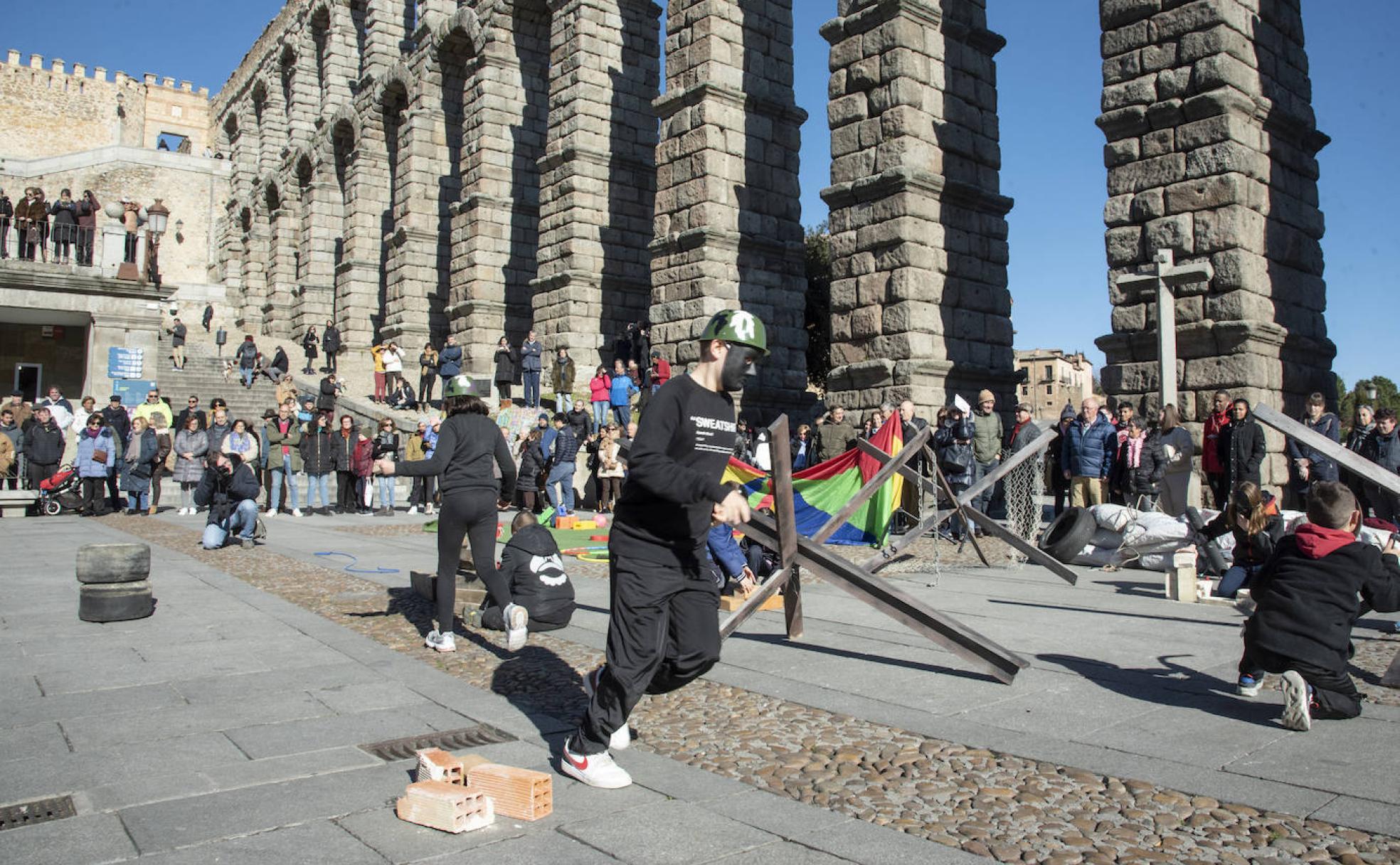 Escolares participan en una performance contra la guerra, a los pies del Acueducto. 