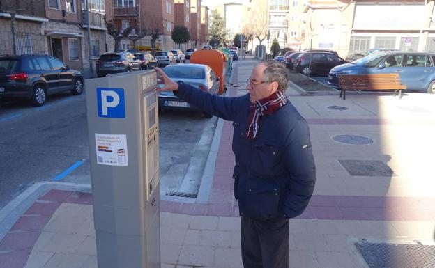 Un vecino observa el nuevo parquímetro de la calle Juan de Herrera, junto al estacionamiento para residentes del patio del colegio Felipe II. 