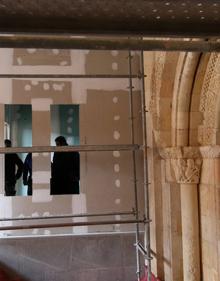 Imagen secundaria 2 - Arriba, salón de grandes dimensiones que alberga un arco. Abajo, obreros junto a la portada románica, desde varias perspectivas. 