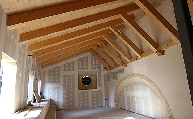 Imagen principal - Arriba, salón de grandes dimensiones que alberga un arco. Abajo, obreros junto a la portada románica, desde varias perspectivas. 