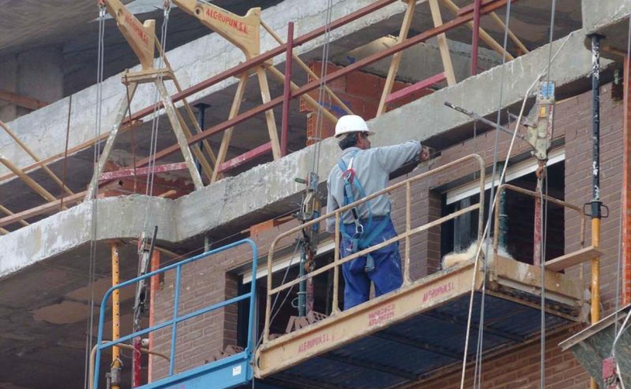 Un trabajador de la construcción en la fachada de un edificio. 
