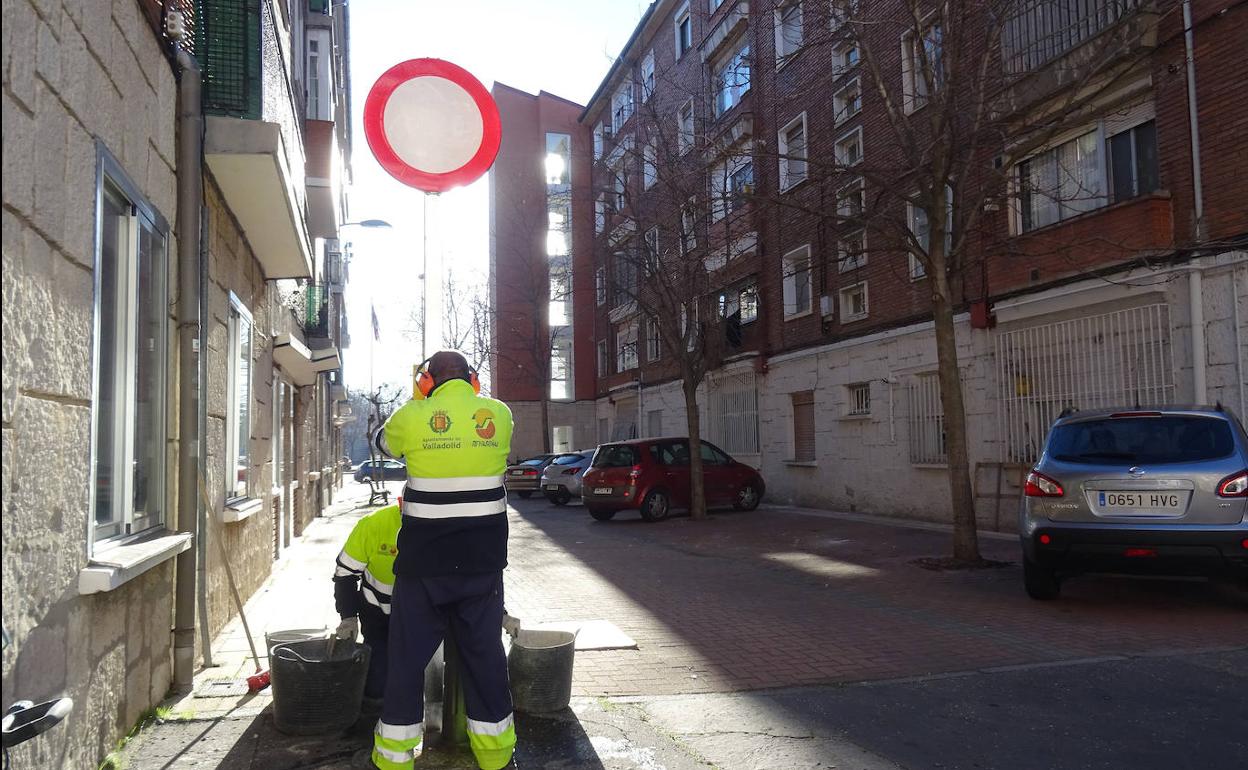 Los operarios colocan la señal que prohíbe circular (y aparcar) en unas de las vías perpendiculares de la calle Juan de Herrera. 