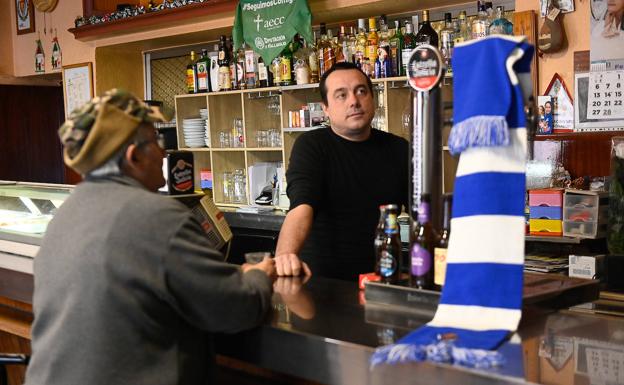 Imagen principal - Uno de los bares de Serrada, decorado con la bandera de la Real Sociedad; el alcalde del municipio, César López, y varios vecinos de la locadlidad