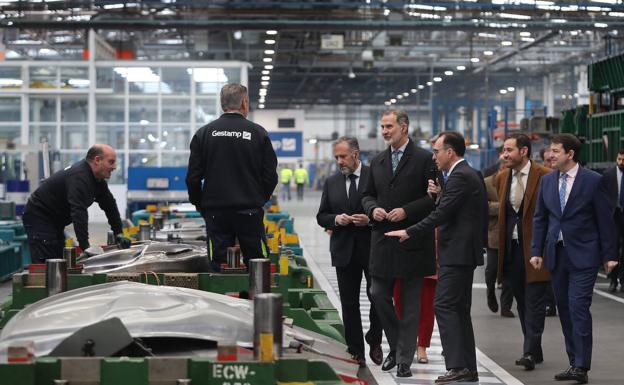 El Rey conversa con unos trabajadores, en la visita a la planta. 