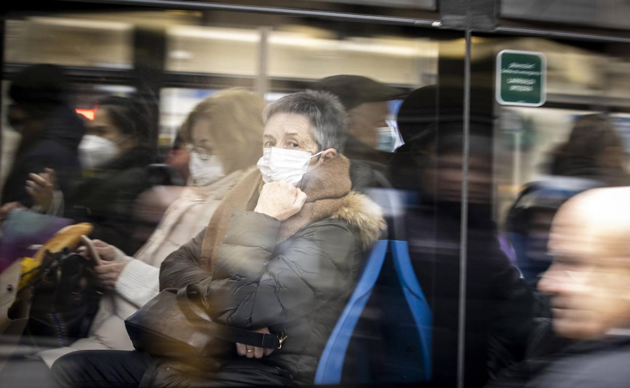 Varias personas viajan con mascarilla en un autobús urbano.