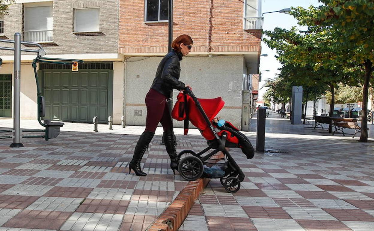 Una mujer empuja una sillita de bebé.