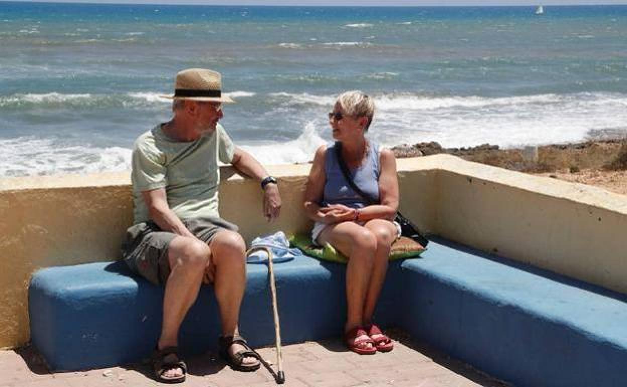 Una pareja de jubilados disfruta de la playa.