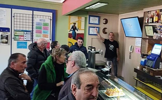 Jesús Alba, al fondo, se congratula por el premio, rodeado de clientes en su bar. 