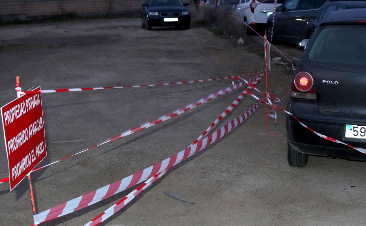 Vehículos aparcados junto al cartel que prohíbe el paso a una propiedad privada próxima a la estación del Ave. 