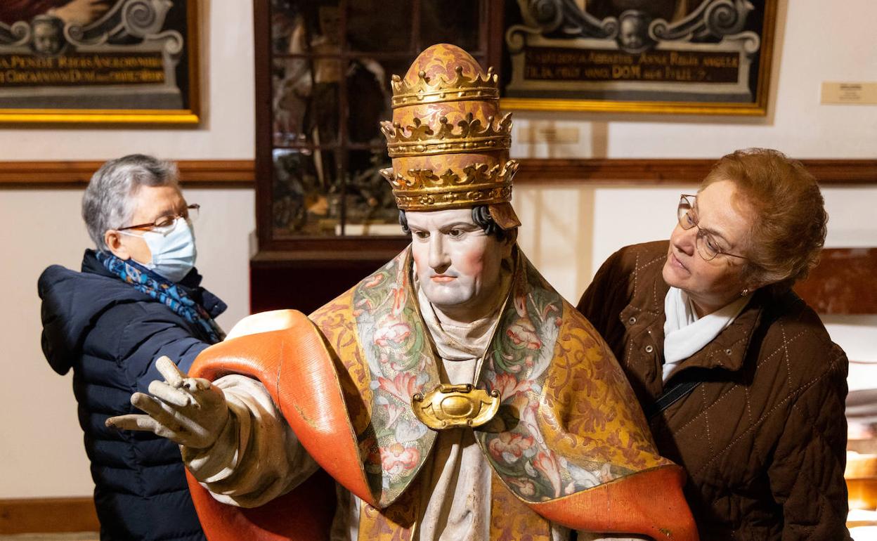 Dos mujeres contemplan la figura de San Gregorio I El Magno, obras de Gregorio Fernández en la sacristía de la iglesia de San MIguel. 