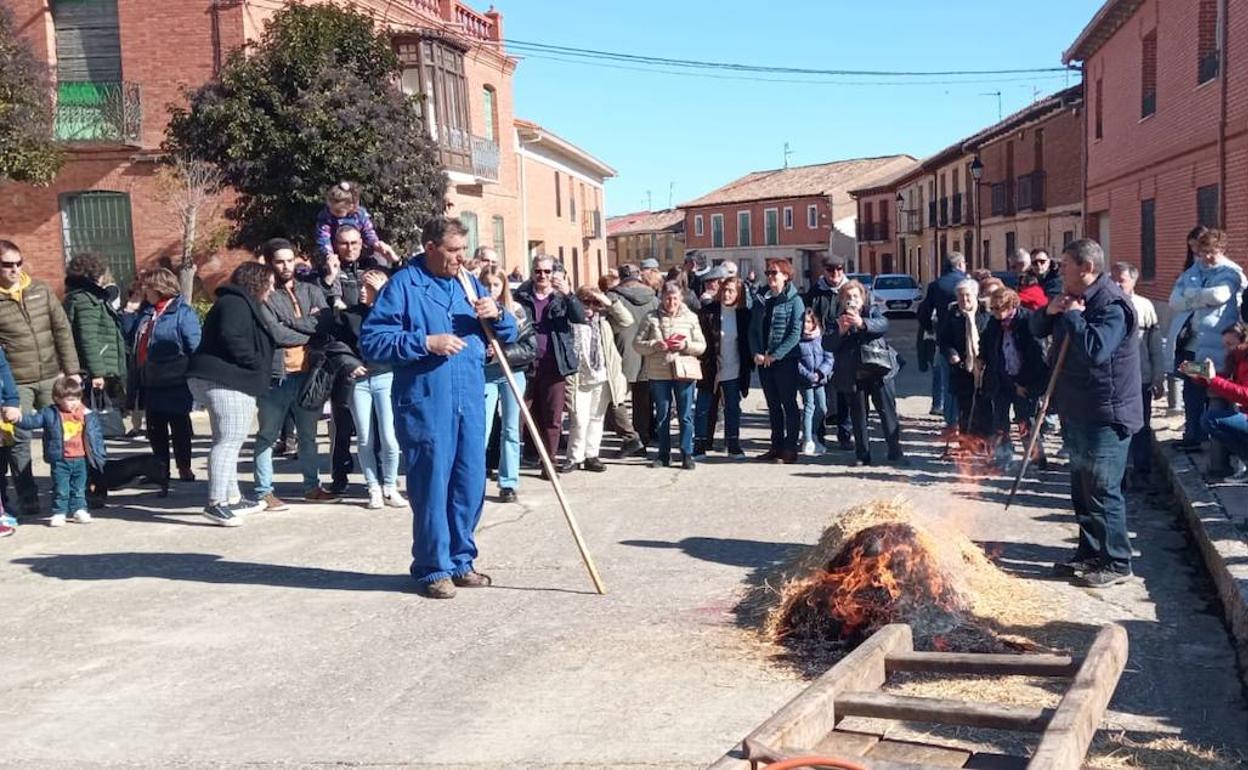 El público contempla los preparativos para el chamuscado del cerdo. 