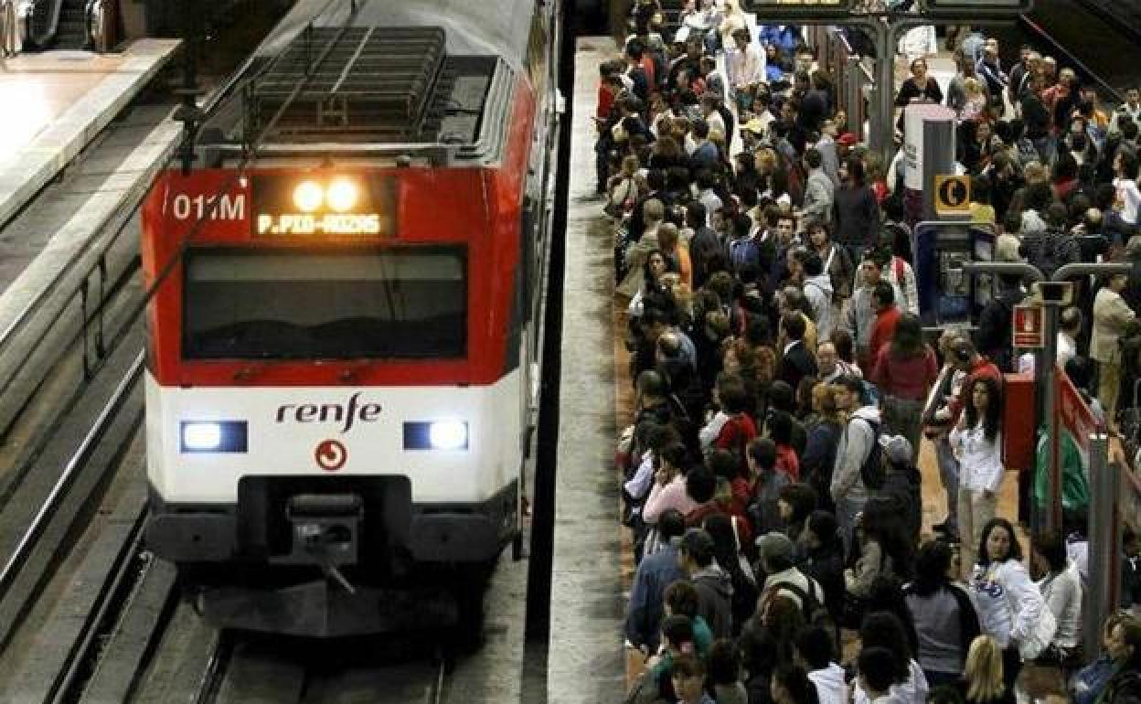 Decenas de viajeros esperan para tomar un tren de cercanías.