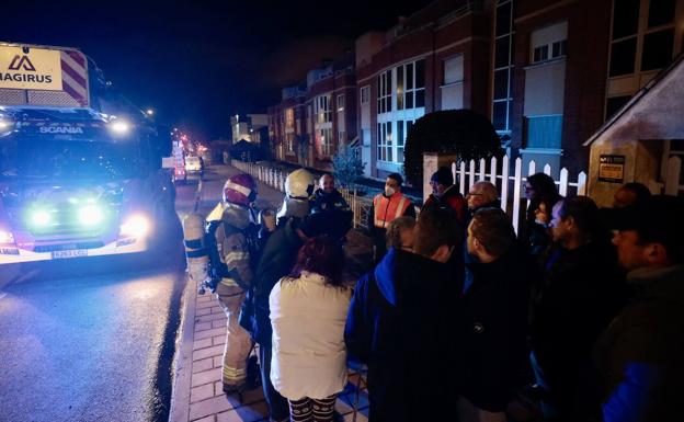 Los vecinos esperan en la calle mientras intervienen los bomberos. 