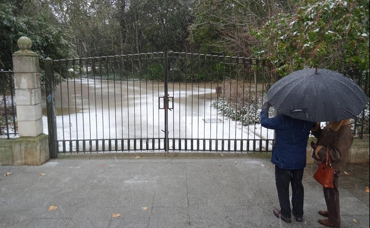 Una pareja fotografía el Campo Grande, cerrado por el temporal. 