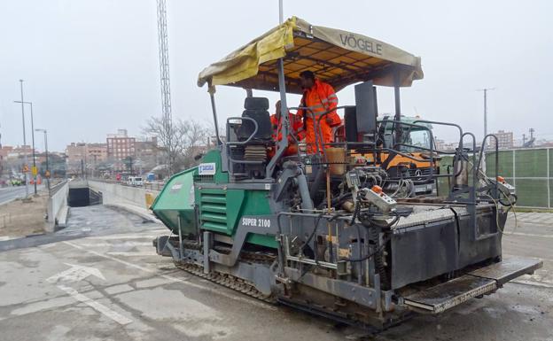 Imagen principal - Arriba, la máquina de asfaltado, lista para acceder a la boca del túnel de la calle Estación. Debajo, a la izquierda, los coches circulan por la calle Loza hacia los vados. A la derecha, remates de las aceras de la calle Panaderos. 