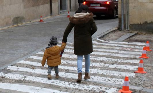 Una mujer acompaña a un menor al colegio. 