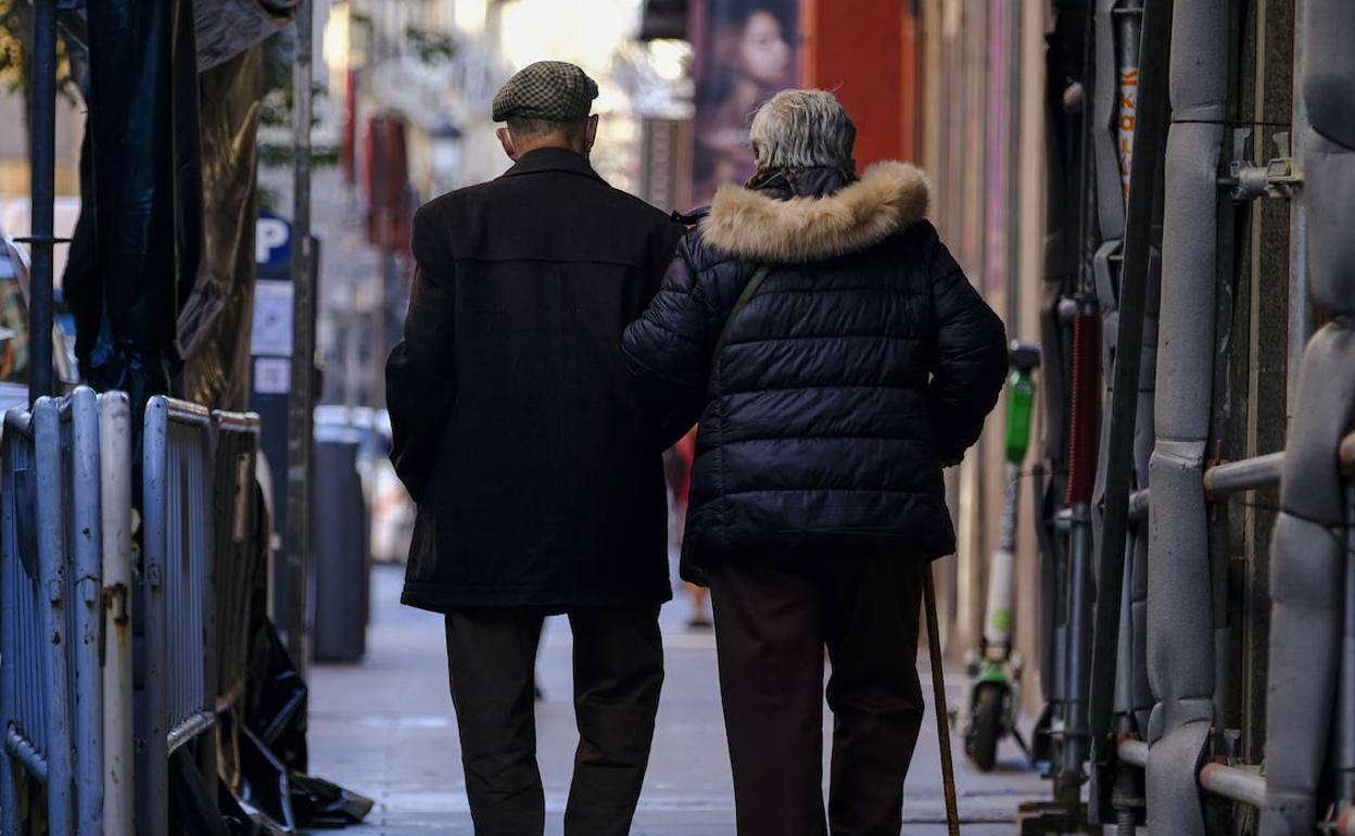 Una pareja de jubilados pasea por las calles.