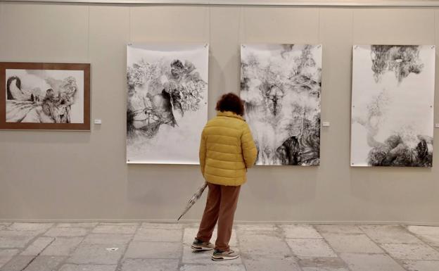 Una mujer, ante cuatro piezas de la serie 'Exploración', de Joaquín Aragón. 