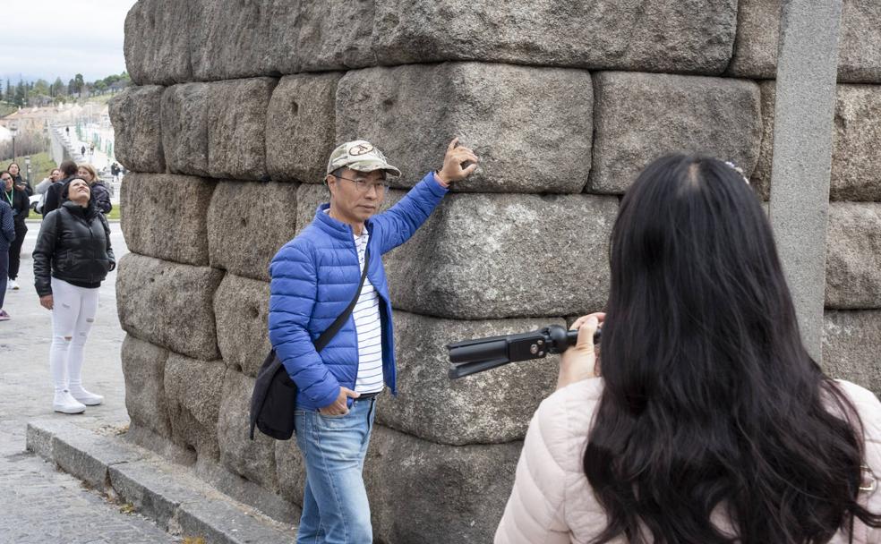 Un turista se apoya en el Acueducto para una fotografía, conducta que puede ser sancionada con hasta 750 euros 