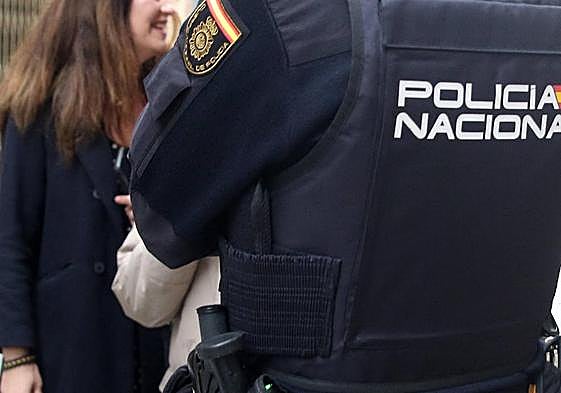 Un agente de la Policía Nacional junto a unos transeúntes en Segovia.