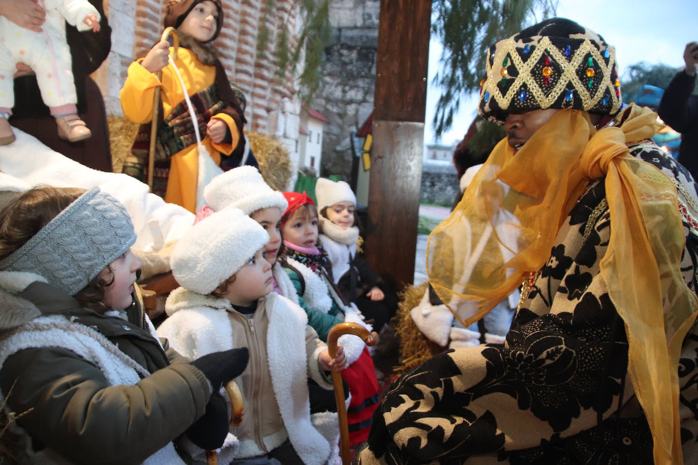 Niños con cara de asombro al saludar a Baltasar en la visita de los Reyes Magos a Cuéllar.