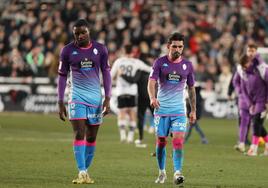 Boyomo y Monchu abandonan cabizbajos el césped del estadio El Plantío tras caer en el derbi.