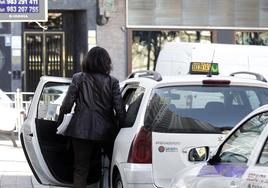 Una mujer se sube en un taxi en la parada de Poniente.