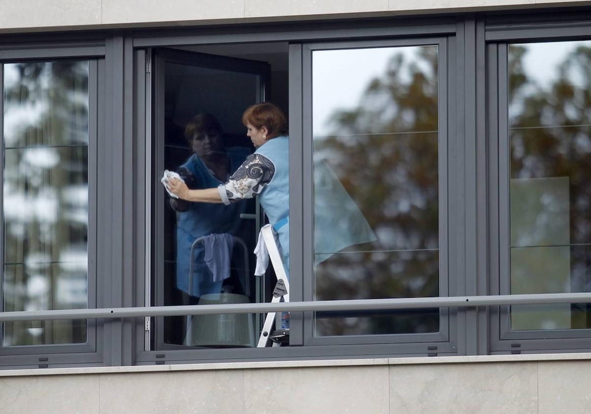 Una trabajadora del servicio de limpieza realiza su labor en unas ventanas, en una imagen de archivo.