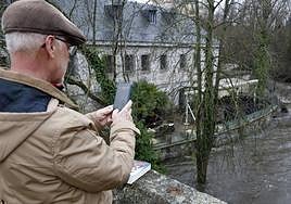 Un hombre saca una foto a la crecida del Eresma.