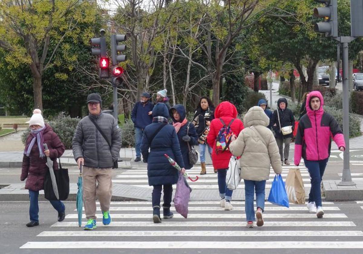 Viandantes se protegen del frío en Valladolid con el paso de la borrasca Juan.