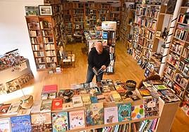 Isaac García ojea una publicación en el primer piso de su librería El Grifilm.