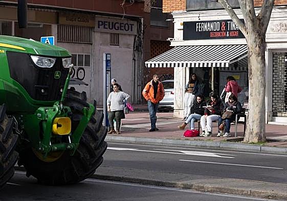 Estudiantes y trabajadores esperan el autobús en la Avenida de Gijón, frente al colegio Cristo Rey.