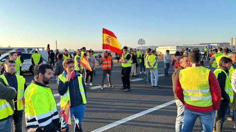 Agricultores, con banderas de España, en el corte de la autovía esta tarde.