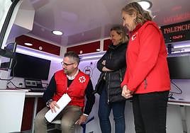 La consejera de Familia, Isabel Blanco, en el centro, con la presidenta de Cruz Roja de Castilla y León, Rosa Urbón, atiende a las explicaciones del técnico Víctor Segura, hoy en Villamuriel.