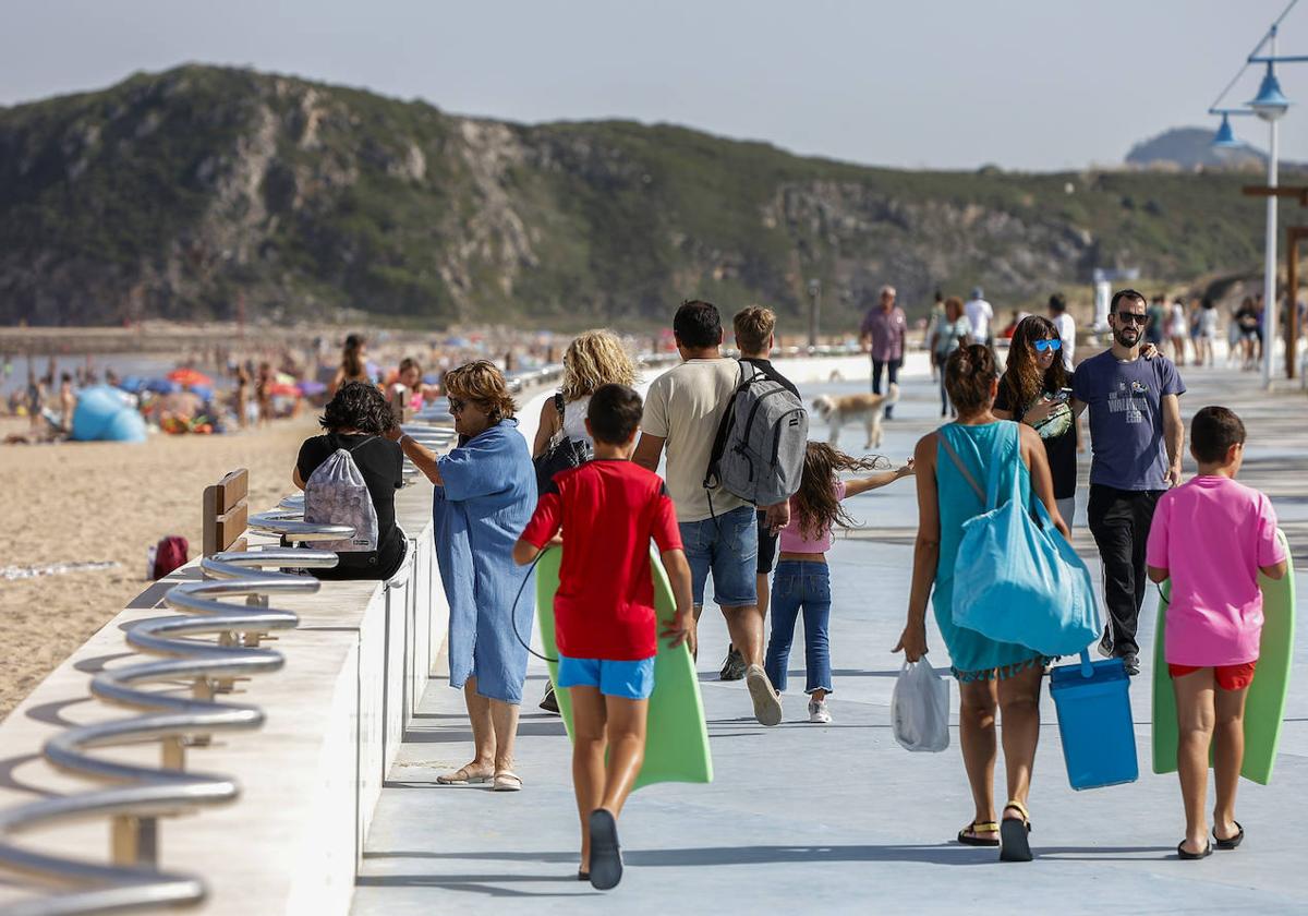 Paseantes junto a la playa de las Conchas, en Suances.