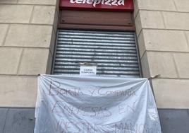 Pancarta colocada en la puerta del establecimiento de Telepizza frente al Acueducto.