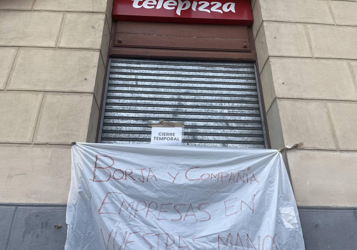 Pancarta colocada en la puerta del establecimiento de Telepizza frente al Acueducto.