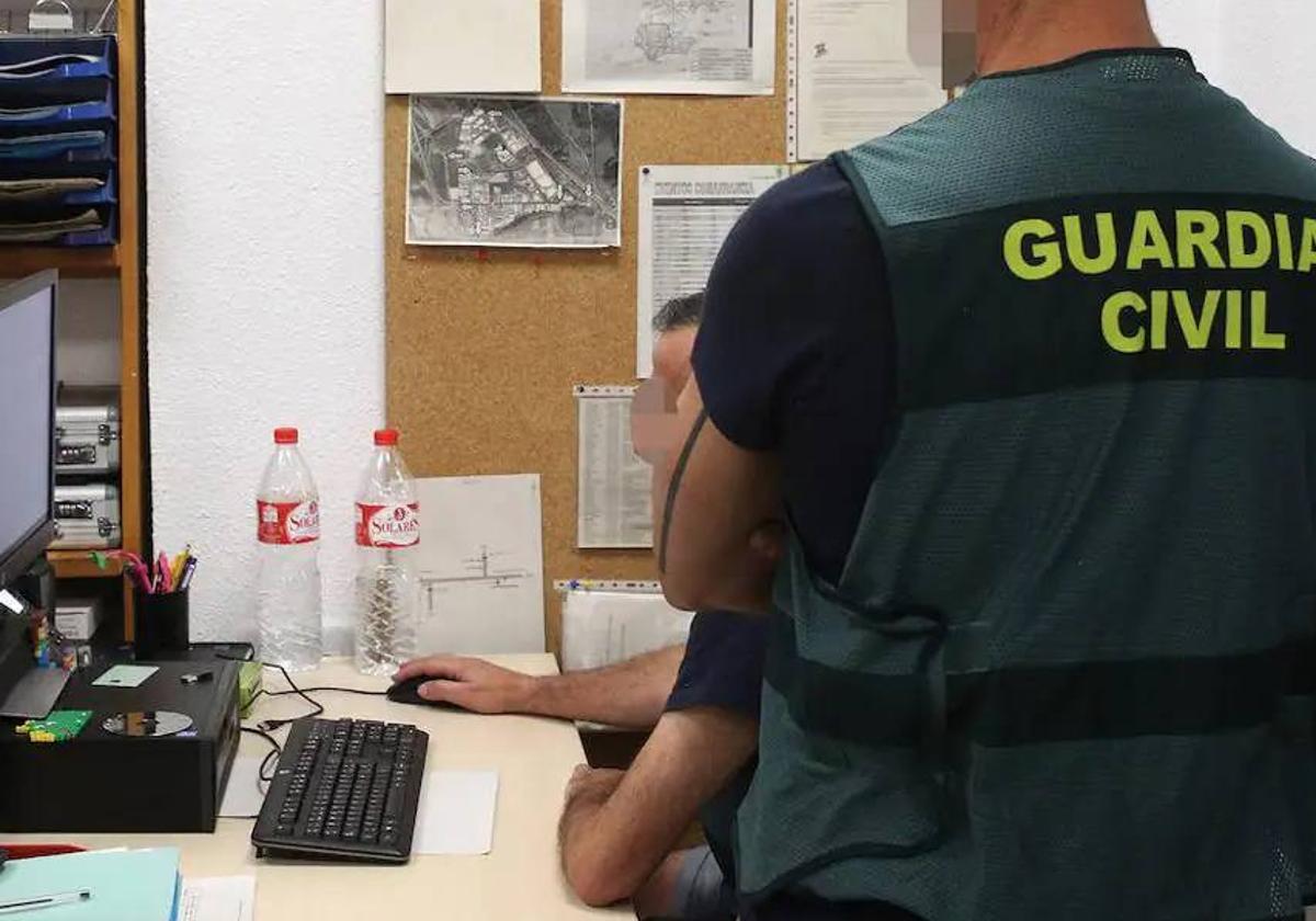 Dos agentes de la Guardia Civil investigan un delito.