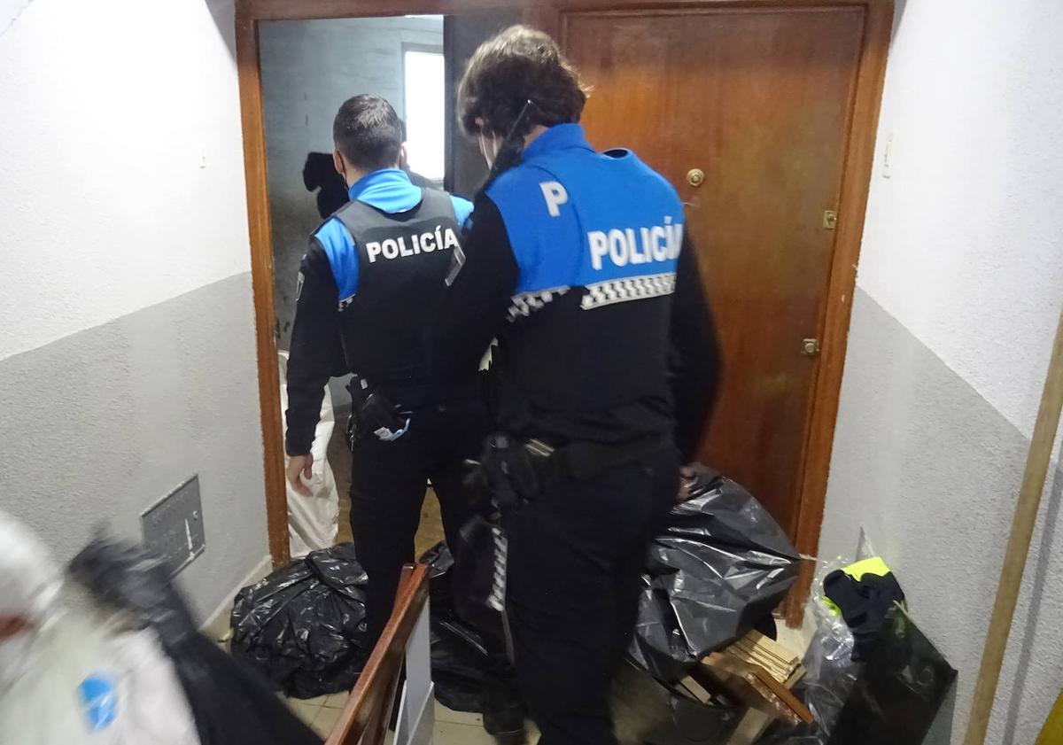 Imagen principal - Policías locales en la vivienda de la vecina de Corpus Christi y cadena de los operarios de Limpieza para retirar la basura acumulada en su interior.