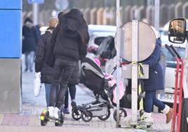 Un patinete circulando por la acera al lado de los peatones.