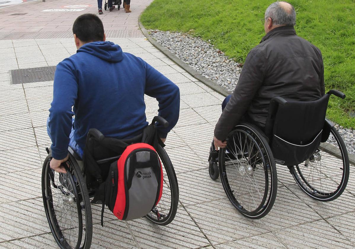 Dos personas en silla de ruedas.