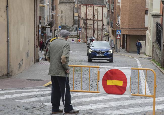 Un anciano observa tras una valla el cambio de sentido en San Antón, cortada al fondo antes de entrar en Blanca de Silos.