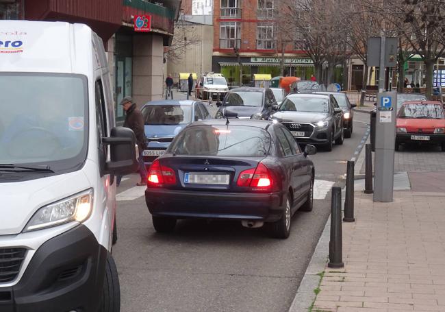 Una furgoneta y tres coches maniobran para entrar y salir de la calle Doctor Montero.